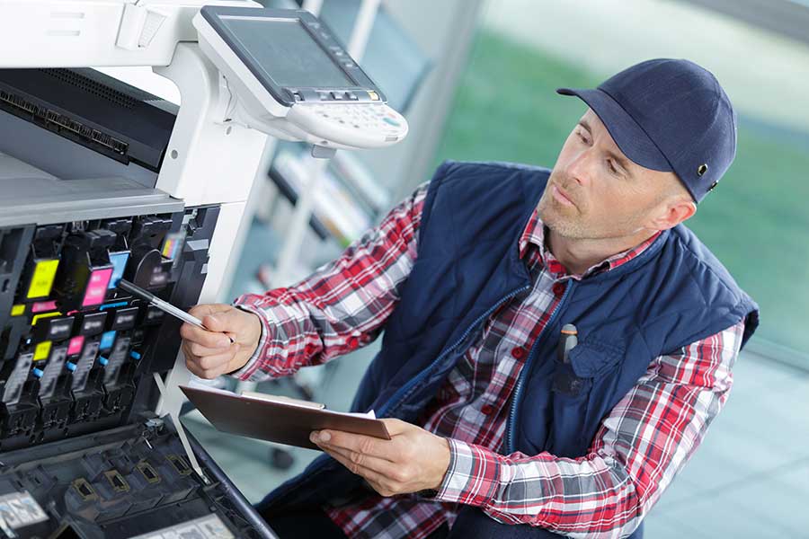 Un technicien intervient sur un multifonction professionnel.